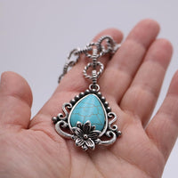 Vintage Style Turquoise Howlite Pendant Necklace, 18 Inch Silver Tone Chain, Floral Design with Ornate Frame